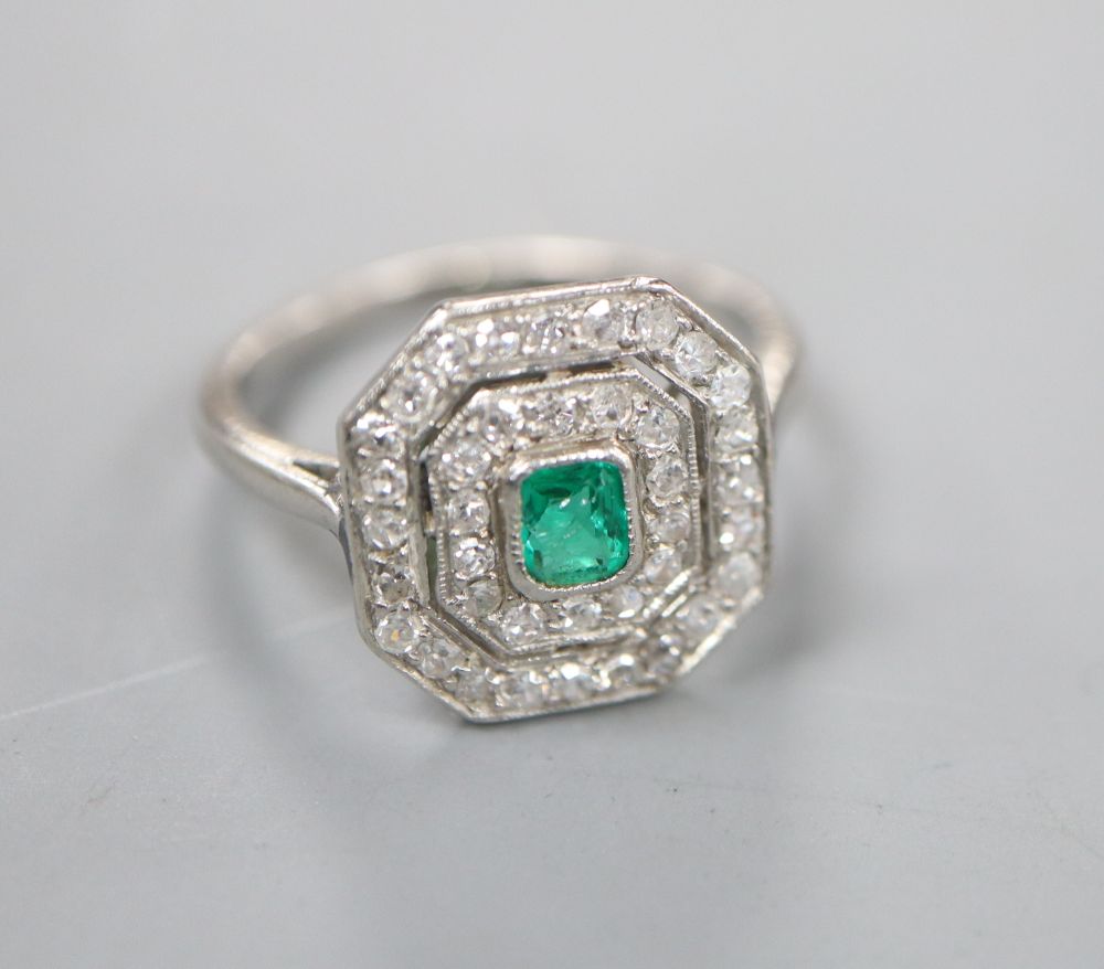 An Art Deco white metal, emerald and diamond set octagonal tablet ring, (emerald chipped), size J/K, gross 3.4 grams.